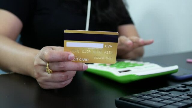 woman hand holding creadit card with calculator for shopping online.