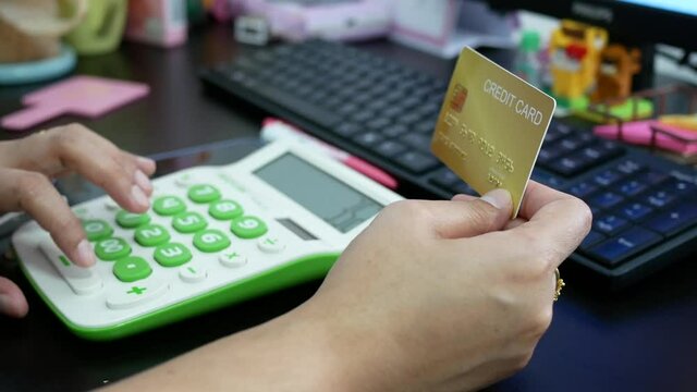 woman hand holding creadit card with calculator for shopping online.