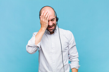 bald man laughing and slapping forehead like saying d’oh! I forgot or that was a stupid mistake