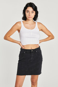 Cool woman in a white crop tank top and a black skirt