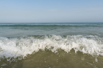 Crashing white waves and blue water and sky from the ocean or sea in the tropical warm holiday climate.