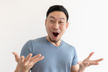 Surprised and wow face of Asian man in blue t-shirt on isolated background.