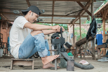 Fototapeta na wymiar tire repairman holds the traditional press with its feet while patching tires in the repair shop
