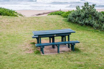 Green Picnic Table on a Grassly Slope Overlooking the Sea