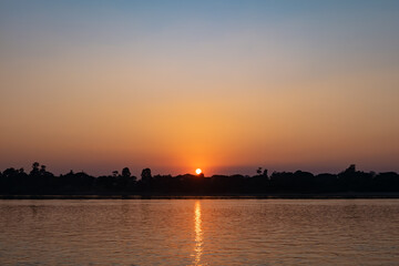 Sunset sky with graduated colors over Mekong riverbank, blue and orange colored sky background.