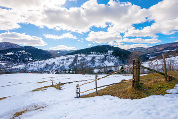 Fototapeta na wymiar mountainous rural landscape on a sunny winter day. fields and trees on rolling hills covered in snow. fluffy clouds on the sky. beautiful carpathian landscape