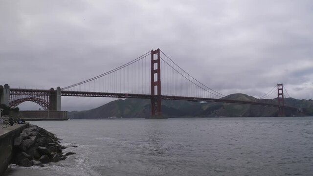 Golden Gate Bridge in San Francisco California on dark overcast cloudy day, Pan right reveal shot