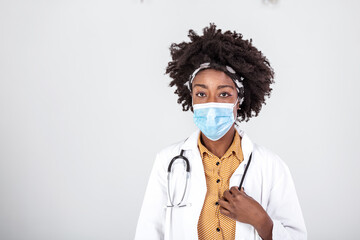 Protect yourself. Portrait of confident black female doctor in face mask over white studio...