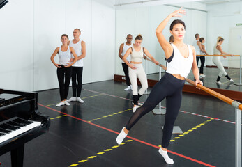Fototapeta na wymiar Lesson in ballet school - men and women perform ballet exercises