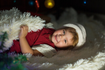 a child in a Santa hat is sleeping New year. the concept of celebrating, enjoying Christmas at midnight. holiday costume