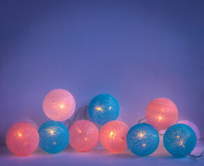 a garland of christmas baubles on dark blue background, glowing lights template, copy space
