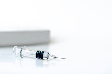 syringe for medical vaccination and packaging on a white background. Syringe with vaccine and a...