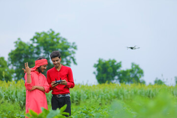 Indian farmer and agronomist using drone at agriculture field