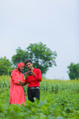 Indian farmer and agronomist using drone at agriculture field
