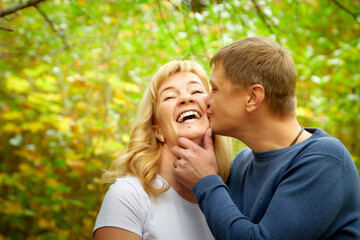 Middle-aged couple walking in the park on an autumn day.