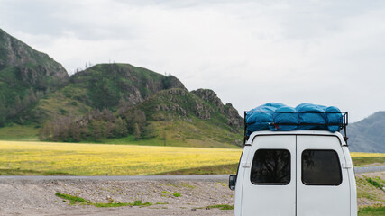 Photo of a Mountain summer Landscape. Travel location of popular tourist attraction. View of beautiful nature. Grassy field, hills and car on cloudy sky background.