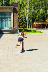 The girl is riding a scooter