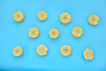 Sweetcorn Against Blue Background. Flat lay composition with tasty sweet corn cobs on color background. Cobs of ripe raw corn on blue background. Top view.