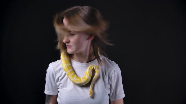 Slow motion shooting of woman with albino python, shaking hair