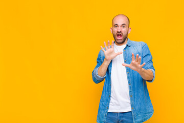 bald man feeling terrified, backing off and screaming in horror and panic, reacting to a nightmare