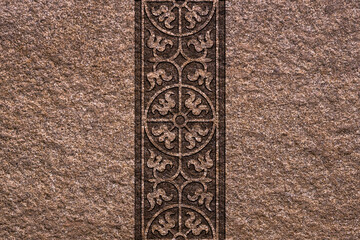 Ornamental print on the stone surface. Vintage ornament on the stone. Embossed drawing. Close-up. Stone texture. Pattern on the stone.Embossed pattern. Wallpaper.Tile.Close-up of gray seamless texture