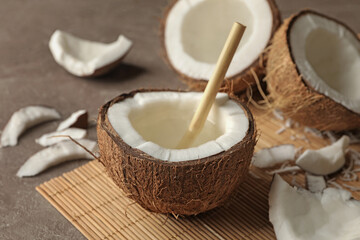 Tasty coconut with straw on bamboo background