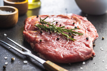Sliced raw ribeye steak on black kitchen table.