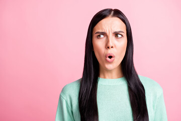 Photo portrait of angry irritated brunette in teal sweater looking at blank space isolated on pastel pink color background