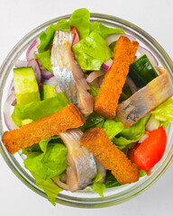 Serving of healthy vegetable salad with fish in a bowl. Delicious snack, healthy eating, isolated on white background.