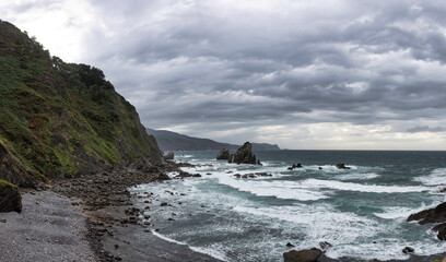 Fototapeta na wymiar natural beach with cliff has a dramatic effect with the clouds