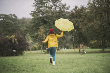 Cute with yellow umbrella running and having fun