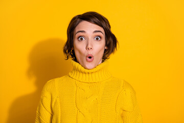 Obraz na płótnie Canvas Photo portrait of shocked surprised female brunette staring with opened mouth in knitted sweater isolated on vivid yellow color background
