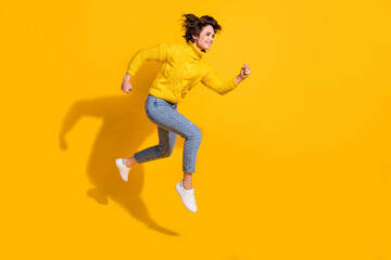 Fototapeta na wymiar Full length body size side profile photo of jumping smiling happy girl running fast on sale isolated on bright yellow color background