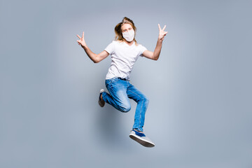 Fototapeta na wymiar Photo of funky long blonde hair guy dressed casual clothes mask jumping up demonstrating v-sign isolated grey color background