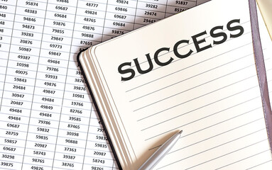 Obraz premium Business concept, on the table a notepad with the text of the SUCCESS on graph