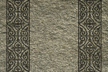 Ornamental print on the stone surface. Vintage ornament on the stone. Embossed drawing. Close-up. Stone texture. Pattern on the stone.Embossed pattern. Wallpaper.Tile.Close-up of gray seamless texture