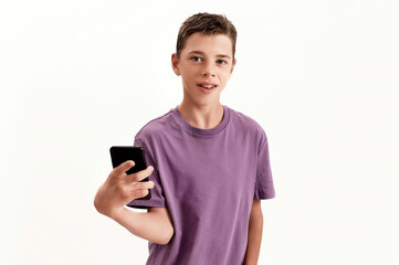 Teenaged disabled boy with cerebral palsy looking at camera and holding smartphone, posing isolated...
