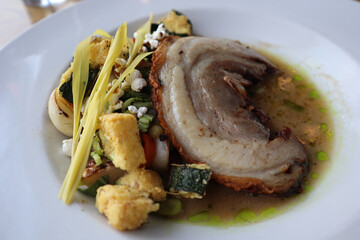 Dinner at an upscale restaurant of duck breast plated with a vegetable medley