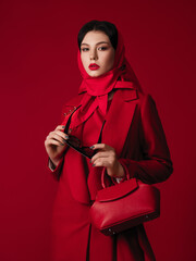 total red look style fashion studio portrait of a gorgeous young brunette woman, coat, bag,...