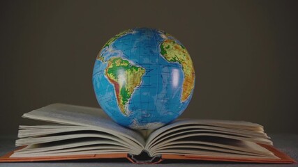 Environmental Education Day. Open book and earth globe. Close-up.