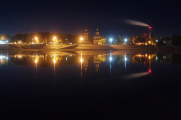 embankment of an ancient city reflected in the river at night