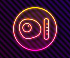 Glowing neon line Traditional british breakfast, fried eggs with sausage icon isolated on black background. Vector.