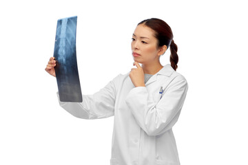 medicine, radiology and healthcare concept - asian female doctor in white coat looking at x-ray...
