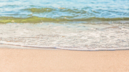 the waves of the sea on the sandy beach on a sunny day