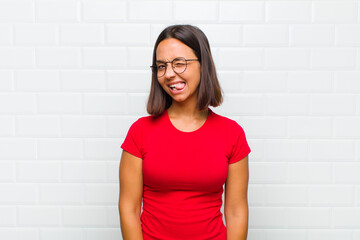 latin woman with cheerful, carefree, rebellious attitude, joking and sticking tongue out, having fun