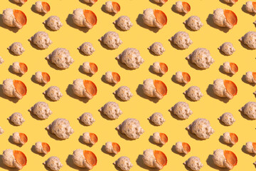 Seamless regular pattern with seashells on a yellow background. Hard light. Summer vacation and travel concept.