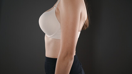 Woman in in beige bra on a black background