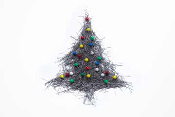 Concept merry xmas in the office. Сhristmas tree and decorations made of stationery or sewing pins on a white background