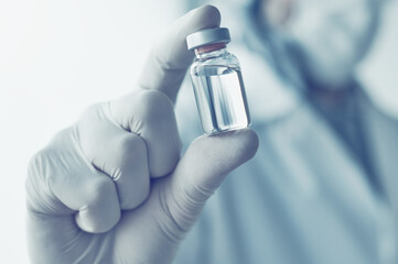 Medical doctor holding vaccine vial for coronavirus vaccination concept