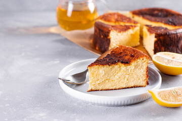 Piece of San Sebastian Basque Cheesecake on the plate on a background. Copy space